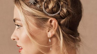 Mulher com penteado sofisticado usando acessórios de cabelo metálicos.